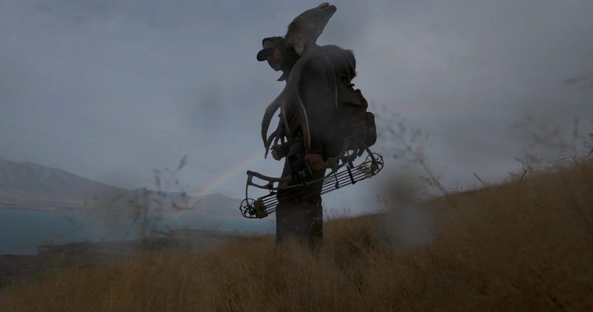 Silhouette of a hunter packing out through fog